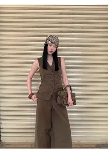 Fashion model wearing minimalist brown high-waist wide-leg pants and matching vest.