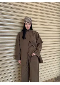 Model wearing minimalist brown cotton-blend high-waisted wide-leg pants in urban setting