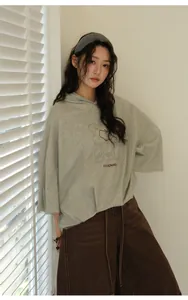 Detail showing the loose fit and graphic print on this grey Korean style hoodie.