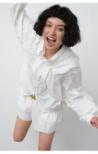Model wearing a white loose-fitting zippered sun protection hoodie and matching shorts set
