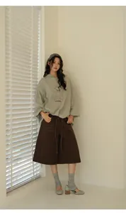 Full-body view of a model wearing a grey oversized hoodie and brown culottes set