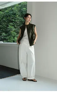 Ganzkörperansicht einer stylischen dunkelgrünen Kunstlederweste mit weißer Hose