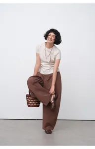 Woman wearing a slim-fit pleated short sleeve summer T-shirt in a casual studio setting
