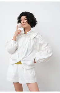 Woman wearing a lightweight white hooded sun protection jacket with matching shorts.