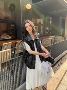 Stylish street style shot of a women's black PU leather vest featuring intricate lace lining