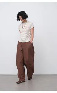 Fitted beige cotton short sleeve T-shirt styled with brown wide-leg trousers