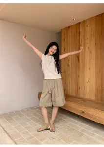 Model wearing a minimalist linen blend sleeveless knitted top with natural texture
