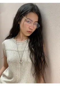 Close-up detail of a minimalist sleeveless cream linen blend knit top worn by model