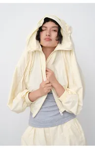 Close-up of a loose-fit hooded sun protection jacket in light yellow for summer wear