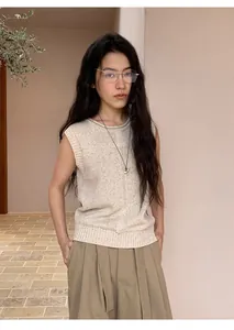 Asian model wearing a minimalist beige linen blend sleeveless knit vest in outdoor setting