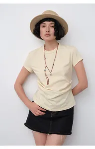 Detail view of a slim-fit pleated yellow T-shirt with a stylish horse pendant necklace