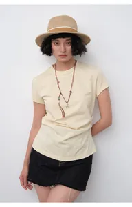 Detail of a slim-fit cream T-shirt featuring stylish waist pleats for a chic summer look.
