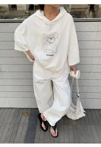 Oversized white hoodie for women featuring a graphic apple print and Innovate text.