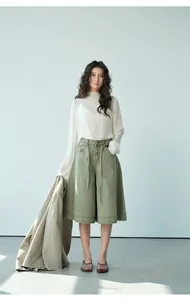 Dettaglio del look completo con camicetta bianca trasparente e culotte verde oliva.