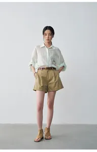 Female model wearing casual khaki pleated shorts with cuffed hem and mint linen shirt