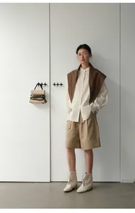 Detalle del look completo con pantalones cortos caqui y camisa de rayas para mujer