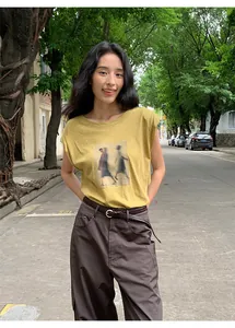 T-shirt imprimé jaune moutarde à manches volantées avec un pantalon marron pour femme.