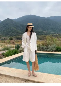 Blazer bianco in stile coreano indossato da una modella in un resort all'aperto