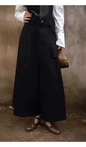 Détail de jupe-culotte noire minimaliste associée à des sandales marron vintage.