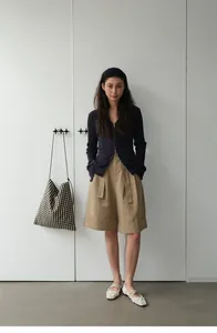 Modelo con pantalones cortos kaki de corte A y dobladillo con cárdigan azulado