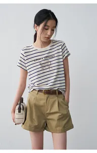 Model wearing casual pleated khaki shorts and a striped T-shirt in a studio setting