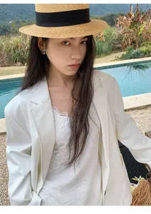 Elegante blazer bianco minimalista in stile coreano per donna in un ambiente da resort