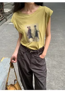T-shirt jaune moutarde à manches courtes avec imprimé artistique de personnages flous.