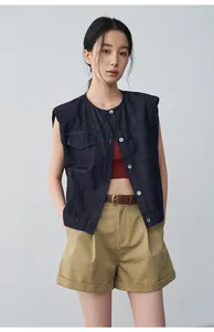 Detail showing the fit and texture of women's khaki pleated shorts with rolled cuffs.