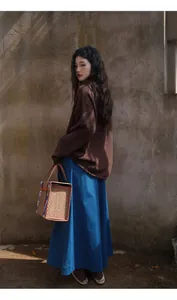 Vue complète élégante d'une jupe-culotte bleue avec un pull en maille marron