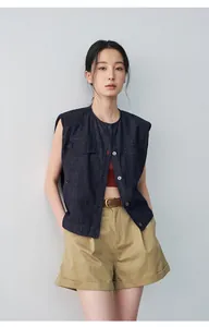 Close-up detail of women's khaki pleated mid-waist cuffed shorts in a stylish casual outfit