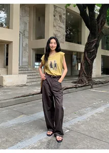 Photo de style urbain d'un t-shirt sans manches imprimé jaune moutarde et d'un pantalon marron.