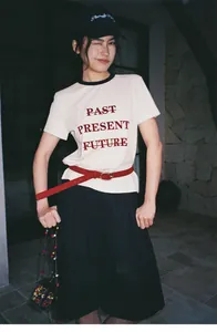 Foto de estilo de vida de pantalones cortos negros anchos con camiseta vintage y cinturón.