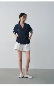 Full body view of women's summer white pleated mid-waist rolled hem casual shorts