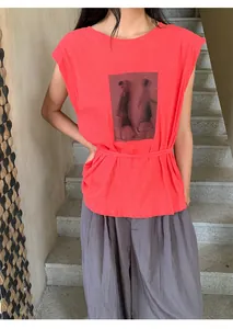 Détail d'un t-shirt rouge vif à manches courtes avec un imprimé graphique vintage.