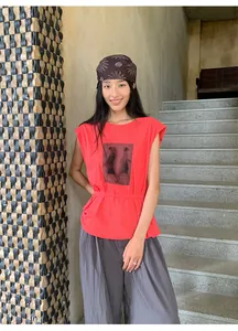 Vue en pied d'une femme portant un t-shirt rouge imprimé à manches volantées et pantalon