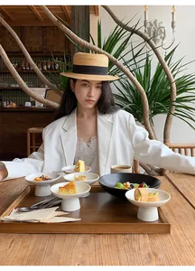 Donna alla moda che indossa un blazer bianco sottile e minimalista in un caffè chic