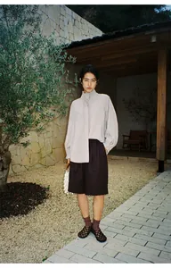 Detalle de pantalones cortos mujer línea A largo rodilla con vuelta en jardín minimal.