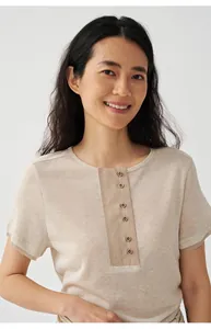 Close-up of a women's beige Tencel-linen blend knit T-shirt with button detail