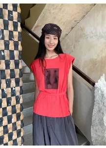 Détail de l'imprimé artistique et de la coupe sans manches du t-shirt en coton rouge.