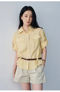Model wearing casual beige cuffed shorts and yellow striped shirt against a plain wall.