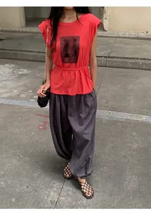 Vue complète d'un mannequin portant un haut d'été rouge à manches volantées et un pantalon