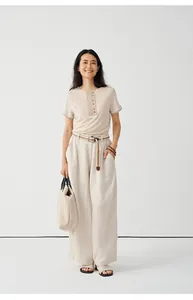 Full body view of a beige Tencel-linen blend knit T-shirt with buttoned neckline detail