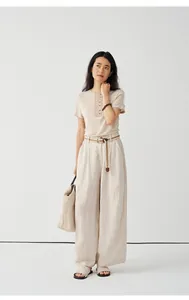 Elegant woman wearing beige Tencel linen knit short sleeve T-shirt and wide pants