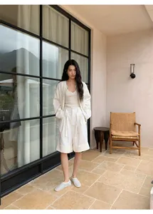 Vista de cuerpo entero de shorts blancos de tiro alto línea A con vuelta chic.