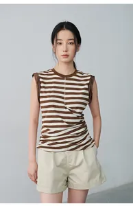 Full outfit detail featuring beige cuffed shorts and a brown striped sleeveless top