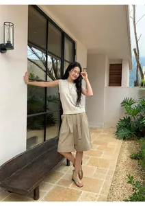 Modelo asiática con pantalones cortos caqui de línea A con dobladillo y un top de punto
