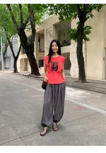 Tenue complète avec un t-shirt rouge à manches courtes et un pantalon gris ample.