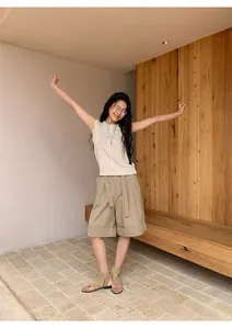 Modelo con pantalones cortos informales caqui de corte evasé con dobladillo