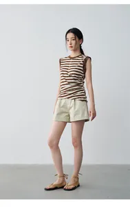 Full-body view of model wearing beige rolled-edge shorts and striped top in studio