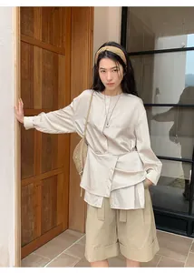 Modelo con pantalones cortos casuales beige línea A y dobladillo enrollado alto.